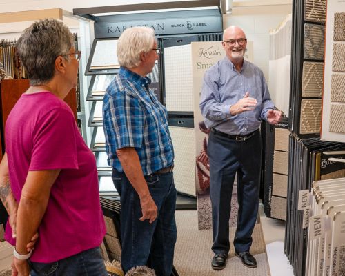 Customers working with a flooring designer at Carlson’s Floors showroom in Geneva IL exploring wool carpet options
